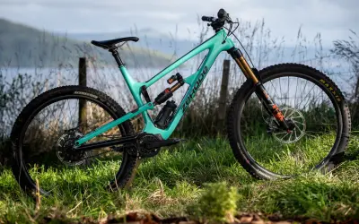 Turkusowy rower full-suspension marki Zerode, gotowy na górskie trasy. Wśród wielu marek rowerów, ten wyróżnia się designem.