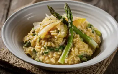 Risotto cremoso con asparagi freschi e scaglie di parmigiano. Un perfetto abbinamento asparagi per un piatto primaverile.