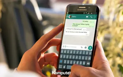 Dłoń trzyma smartfon z otwartym WhatsAppem, pokazując rozmowę. Dowiedz się, jak zainstalować WhatsApp.