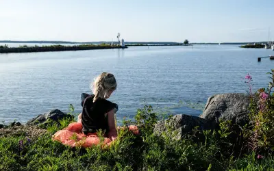 Flicka i tyllkjol vid vattnet nära ett vandrarhem i Mariestad.