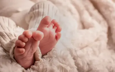 Petits pieds de bébé, tendrement enveloppés dans une couverture douce. Une image symbolisant la pureté et le début d'une nouvelle vie, peut-être en attente de la circoncision islam 7 jours.
