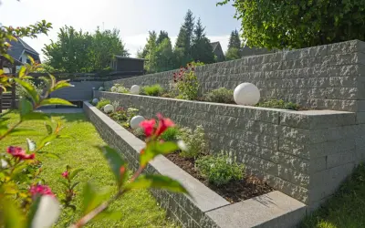 Moderne Gartenmauer mit Terrassierung und dekorativen Kugeln. Tolle Ideen für Gartenmauern, die Struktur und Stil verleihen.