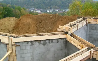 Fundamenty domu w budowie, zbrojenie i szalunki czekają na beton. Widać, ile jest ważne pozwolenie na budowę, by móc rozpocząć taką inwestycję.