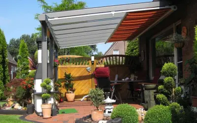 Moderne Terrassenbeschattung Ideen: Eine elegante Pergola mit ausfahrbarem Markisen-Dach schützt die gemütliche Sitzecke im Garten.