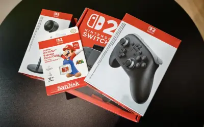 Pudełka z akcesoriami do Nintendo Switch: kontroler Pro, karta microSD 256 GB z Mario i kamera.