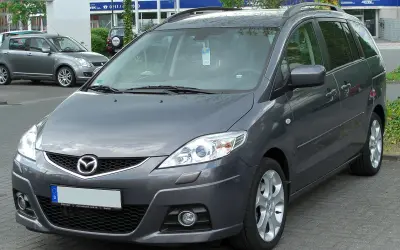 Szary Mazda 5 2.0 diesel zaparkowany na zewnątrz.