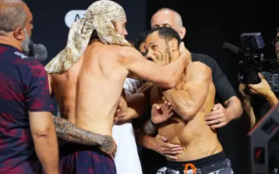Två MMA-fighters, en med huvudduk, brottas under en vägning. Cody Brundage är en av dem.