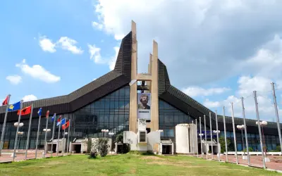 Prisztina, jego stolica, wita gości przed budynkiem z portretem Adema Jashari. Flagi powiewają na wietrze.