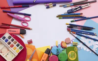 Bunt und ordentlich: Buntstifte, Scheren, Wasserfarben und mehr liegen bereit, um Schulsachen zu organisieren.