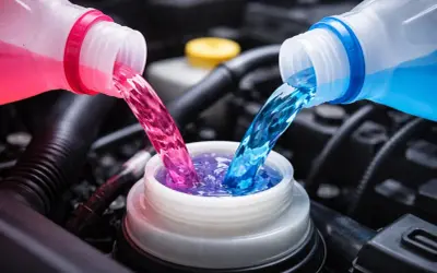 Deux liquides de refroidissement, rose et bleu, se mélangent dans un réservoir. La question est : peut-on mélanger les liquides de refroidissement ?