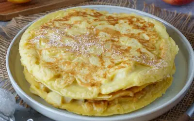 Ein gestapelter Apfelpfannkuchen, bestäubt mit Puderzucker. Ein köstliches Apfelpfannkuchen Rezept, das man ausprobieren muss!