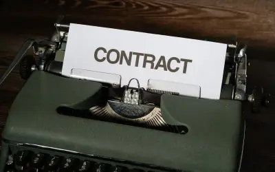 Stara maszyna do pisania z kartką z napisem "CONTRACT". Czas na wypowiedzenie umowy B2B.