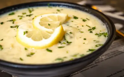 Aksamitna zupa cytrynowa, ozdobiona plasterkami cytryny i posypana natką pietruszki, kusi swoim aromatem.