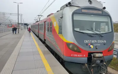 Pociąg EN57 AKM-3004rb z napisem "WARSZAWA" na stacji. Sprawdź rozkład jazdy Nowy Dwór Mazowiecki, aby zaplanować podróż.