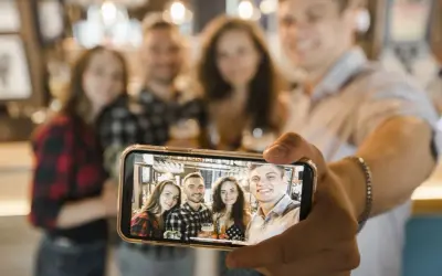 Grupa przyjaciół robi sobie zdjęcie grupowe telefonem. Oto jak zrobić selfie telefonem, by uchwycić wspólne chwile.