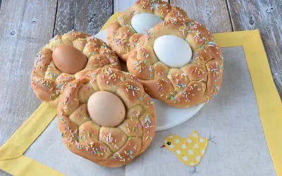 Nidi di Pasqua intrecciati, decorati con codette colorate e uova, pronti per la festa.