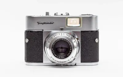 A vintage silver and black Voigtländer camera with a prominent lens and viewfinder.