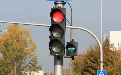 Sygnalizacja świetlna z czerwonym światłem i zielona strzałka wskazująca skręt w prawo.