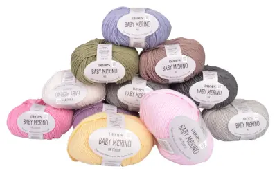Här är ett urval av DROPS Baby Merino-garn i olika färger, perfekt för att sticka en mjuk babyfilt.
