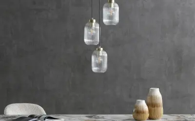 Eleganckie lampy loftowe z przezroczystego szkła wiszą nad marmurowym blatem.