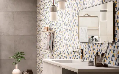 Bagno moderno con parete a triangoli colorati, ideale per chi cerca idee su come rinnovare pavimento in ceramica con stile.