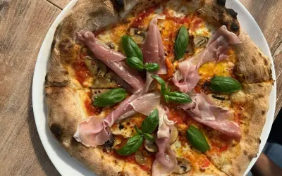 Pyszna pizza z szynką parmeńską i bazylią. Warto sprawdzić ceny w Chorwacji, bo takie smakołyki są warte swojej ceny!