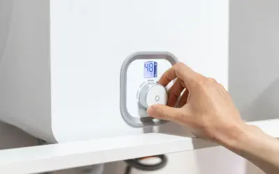 Mano che gira la manopola per spegnere la caldaia a condensazione. Display digitale mostra 48°C.
