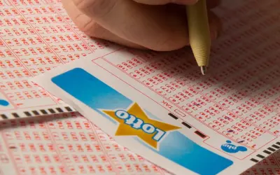 Dłoń zaznacza liczby na kuponie Lotto. Czy to będą zwycięskie lotto kaskada wyniki?