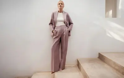 Elegancki różowy garnitur w prążki to idealna propozycja, jak się ubrać na poprawiny. Luźne spodnie i marynarka tworzą stylowy look.