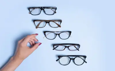 Dłoń wybiera okulary. Czy to będzie ta para, na którą czekałam, by zrealizować recepta na okulary NFZ?
