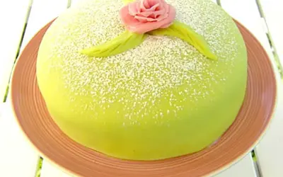 Grön prinsesstårta med rosa marsipanros och blad, pudrad med florsocker. Perfekt för ett prinsesstårta recept.