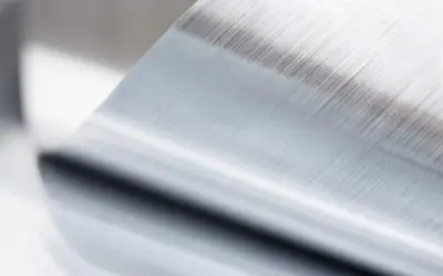 Szczotkowana powierzchnia metalu po procesie anodowania, z widocznymi równoległymi liniami.