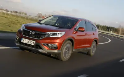 Pomarańczowy Honda CR-V 1.6 diesel na zakręcie drogi. Czy to początek honda cr-v 1.6 diesel usterki?