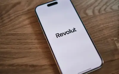Telefon z logo Revolut na ekranie. Dowiedz się, jak wplacić pieniadze na Revolut, aby łatwo zarządzać finansami.