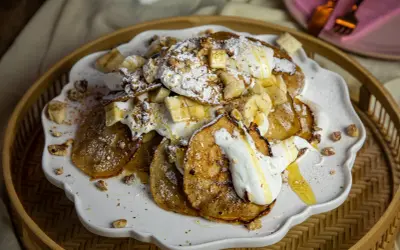 En härlig pannkakstårta med glass, banan och nötter. Pudrad med florsocker och ringlad med honung.