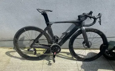 Schwarzes Rennrad mit aerodynamischem carbon rahmen und tiefen Felgen, bereit für die nächste Fahrt.