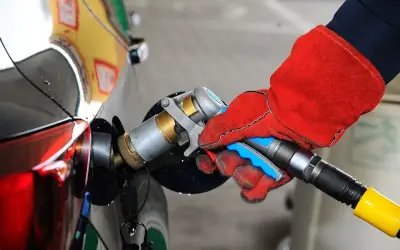 Ręka w czerwonej rękawicy podłącza pistolet do tankowania LPG. To proste tankowanie dla początkujących.