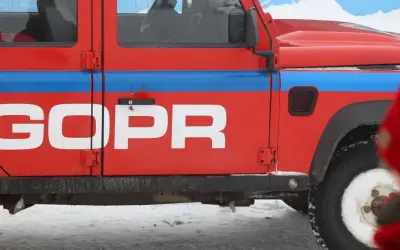 Czerwony samochód GOPR z napisem "GOPR" na drzwiach, gotowy do akcji w Karkonoszach. Sprawdź, jak sprawdzić zagrożenie lawinowe w Karkonoszach komunikaty GOPR.