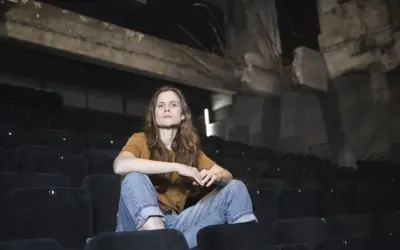 Federica Rosellini seduta tra le file vuote di un cinema, con uno sguardo pensieroso.