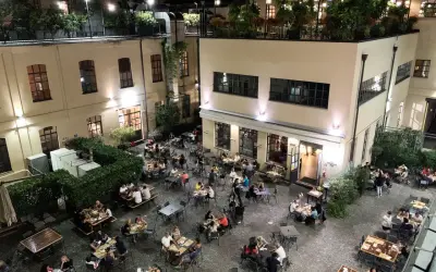 Serata vivace al birrificio La Piazza, con tavoli all'aperto pieni di gente che gode della buona compagnia e delle birre artigianali.