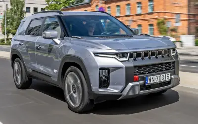 Srebrny SsangYong Torres jedzie ulicą.