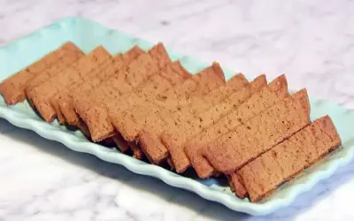 En ljusblå bricka fylld med gyllene, tunna kola kakor. Perfekt för fikat!