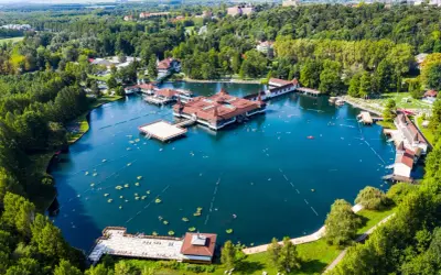 Termalne jezioro z pływającymi budynkami i ludźmi kąpiącymi się w wodzie. To jedno z najpiękniejszych miejsc nad Balatonem.