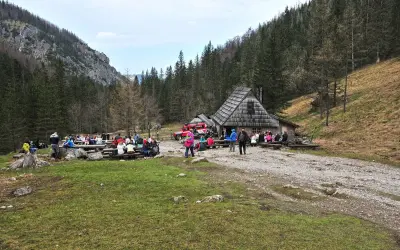 Grupa turystów odpoczywa przy bacówce w Dolinie Strążyskiej. To popularne miejsce, gdzie warto wiedzieć, jak dojechać do doliny strążyskiej.