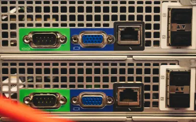 Zbliżenie na tylny panel dwóch serwerów, widoczne porty VGA, RJ45 i SFP. Trwa budowa serwera.