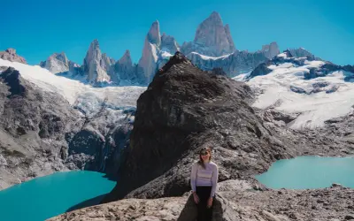 Kobieta na skale podziwia majestatyczne szczyty Patagonii. Firma Patagonia inspiruje do odkrywania piękna natury.
