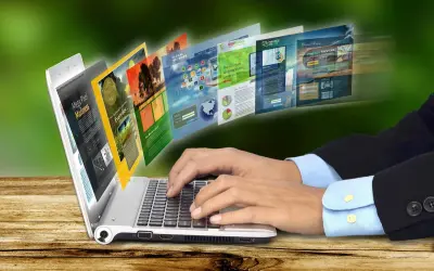 Dłonie piszą na laptopie, z którego wychodzą strony internetowe. To przykład, jak retoryka co to, czyli sztuka perswazji, działa w sieci.
