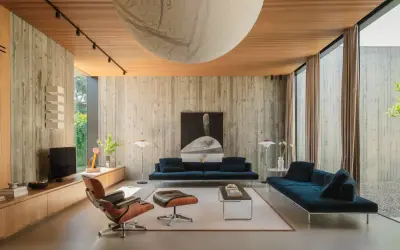 Interni in stile brutalist con pareti in cemento grezzo, soffitto in legno e mobili moderni.