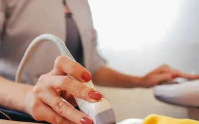 Dłoń trzymająca głowicę USG. Czy można pomylić chłopca z dziewczynką na USG? To pytanie nurtuje wielu rodziców.