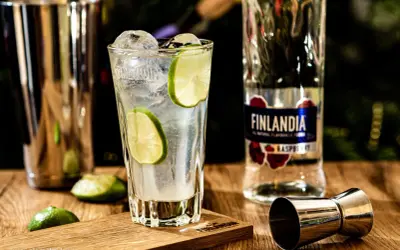 Orzeźwiający drink z lodem i limonką, obok butelka Finlandia Raspberry. Idealny na letnie wieczory.